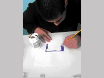 Aluno pintando sobre suporte.
