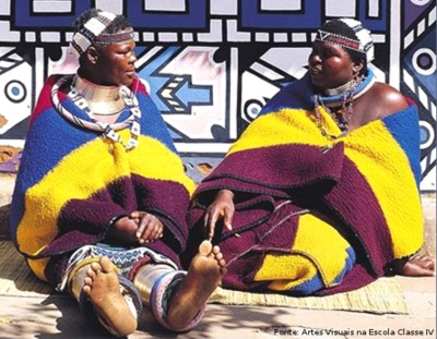 As mulheres da tribo Nbedele, localizada na África do Sul, andam com mantos coloridos amarrados nas costas, como vestimenta.
<br/>
Palavras-chave: mulheres, tribo Ndebele, vestimenta, cobertores, Africa do Sul